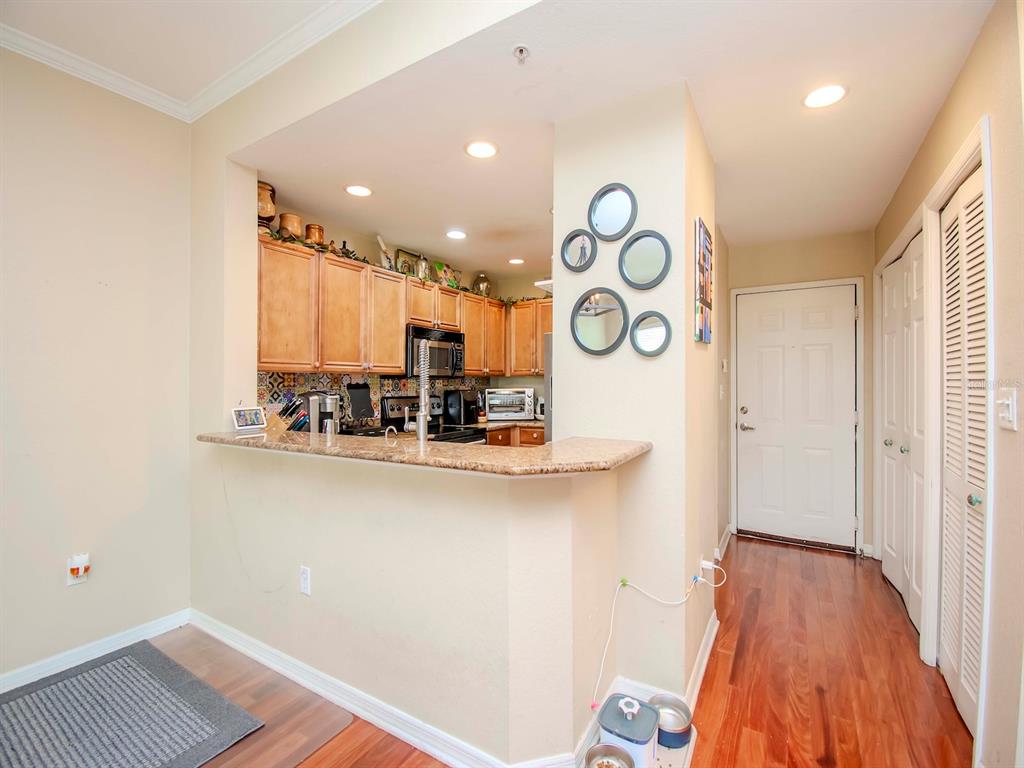 A kitchen with light wood cabinets, a granite breakfast bar, and a tiled backsplash — 700 S HARBOUR ISLAND BOULEVARD UNIT 245, TAMPA, FL