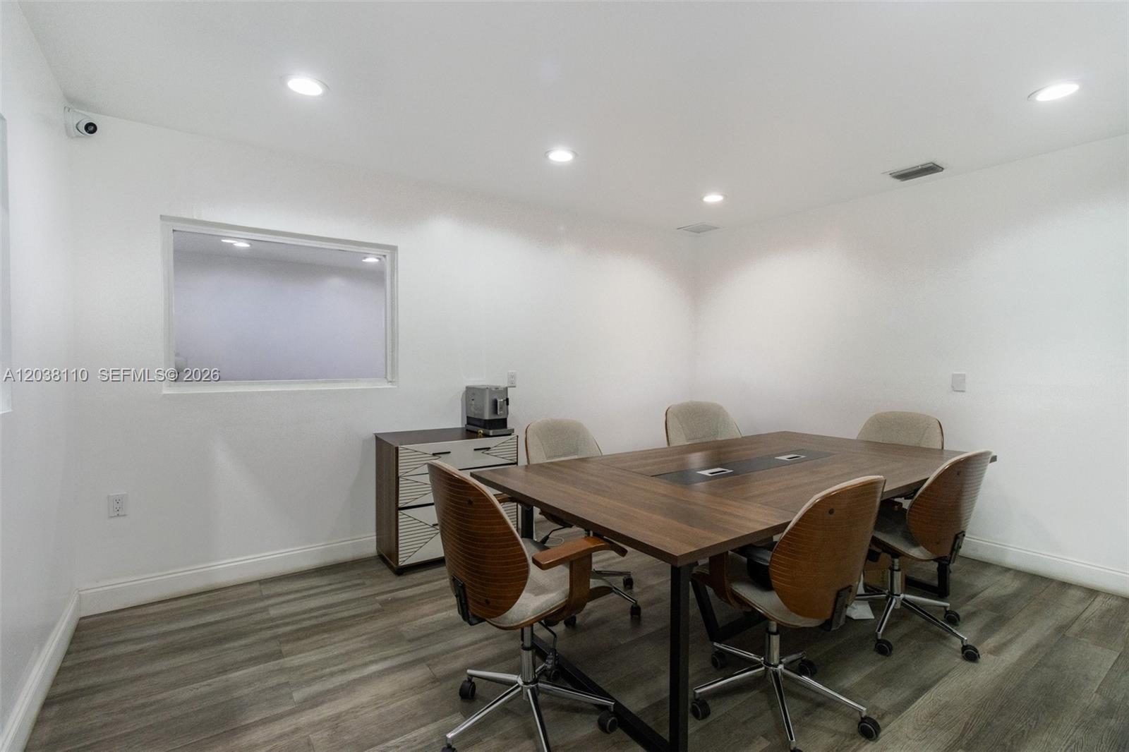 A modern conference room features a wooden table, rolling chairs, and light wood-look flooring — 3337 NW 74th Ave # 3337, Miami FL 33122, MIAMI, FL
