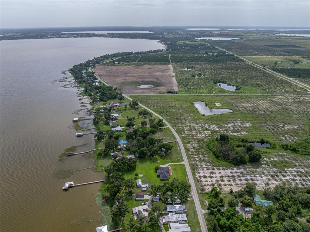 An aerial view shows a road running alongside a large lake with several waterfront homes — 0 LAKE REEDY BOULEVARD, FROSTPROOF, FL