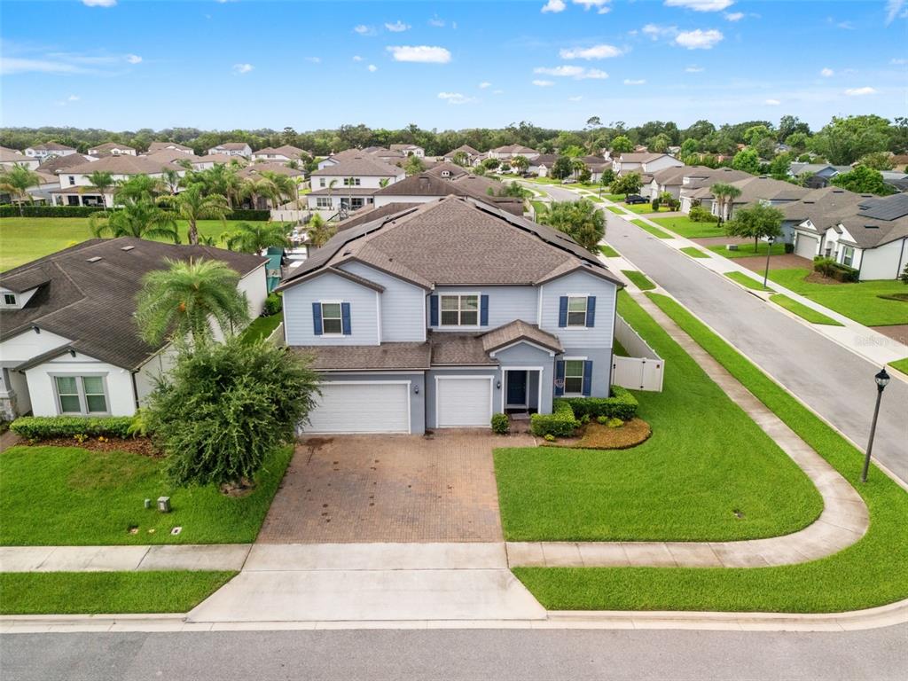 An aerial view of a two-story suburban house with a brick driveway and blue shutters — 3367 CANYON GRAND POINT, LONGWOOD, FL