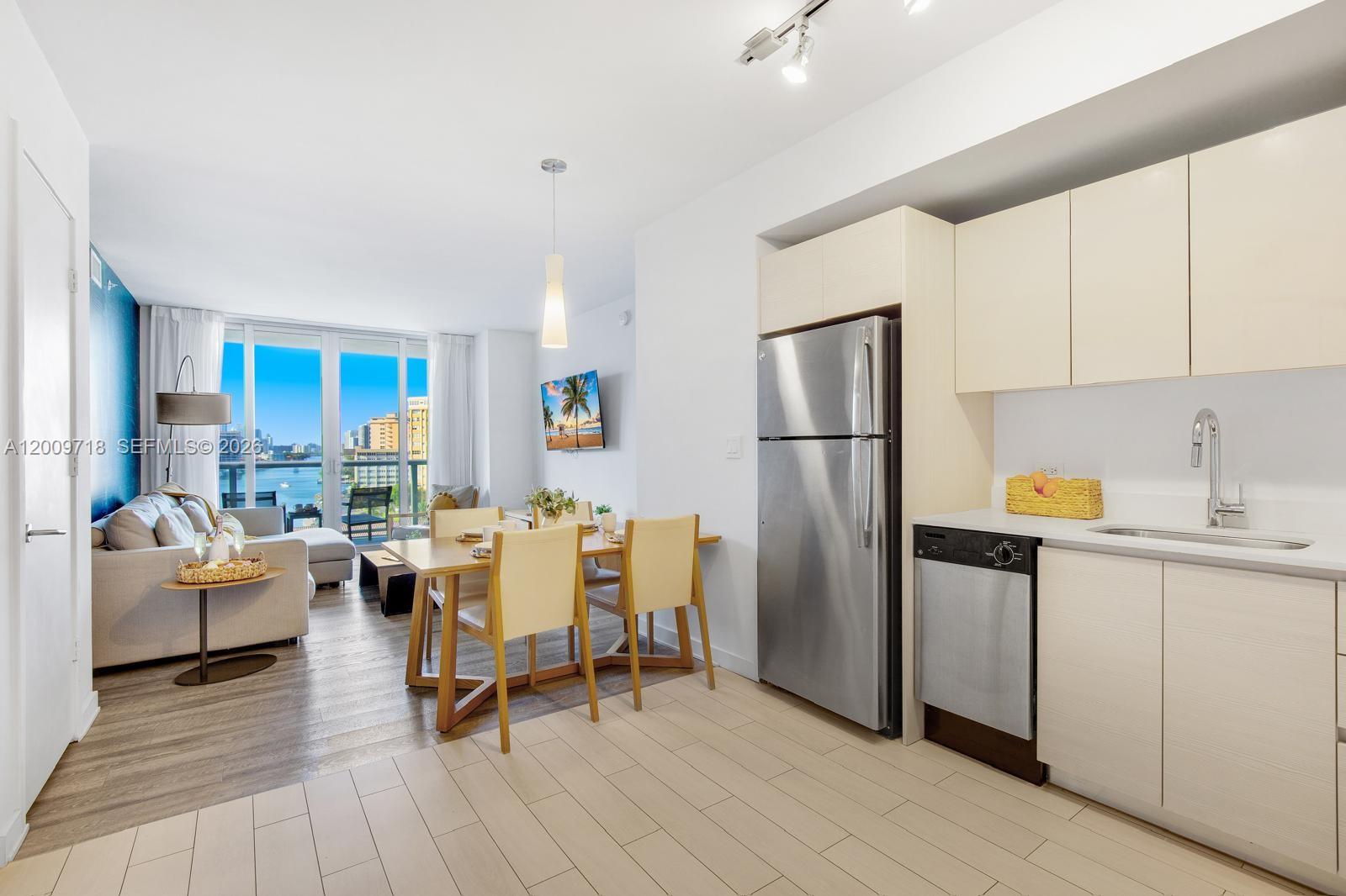 A modern kitchen and dining area open to a living room with a balcony view — 2602 E Hallandale Beach Blvd # R803, Hallandale Beach FL 33009, HALLANDALE BEACH, FL