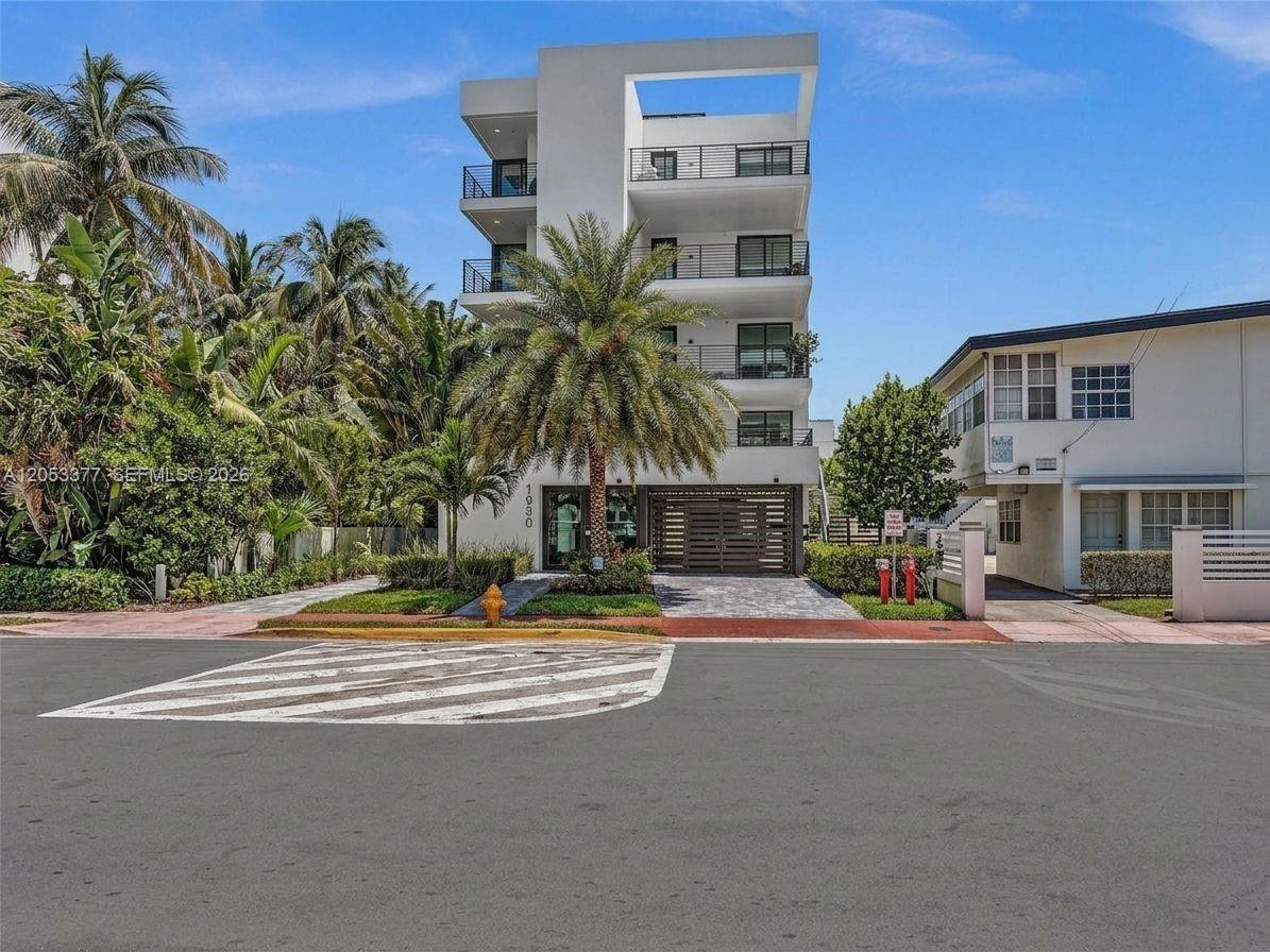 A modern four-story white apartment building stands behind a palm tree and paved driveway — 1930 Bay Dr # 2, Miami Beach FL 33141, MIAMI BEACH, FL
