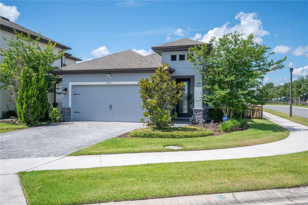 A single-story gray house with a two-car garage and a paved driveway — 1413 BELLAMY DRIVE, REUNION, FL