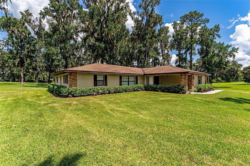 A single-story house with a stone-accented exterior sits on a large, grassy lawn — 5201 NW 78TH COURT, OCALA, FL