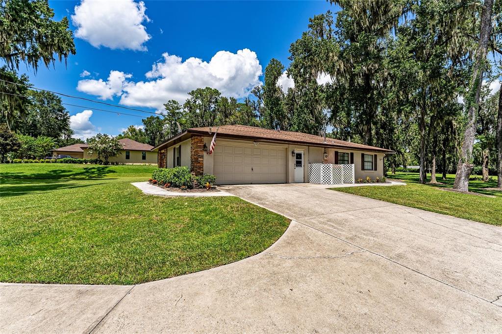 A single-story house with a two-car garage and a concrete driveway sits on a lawn — 5201 NW 78TH COURT, OCALA, FL