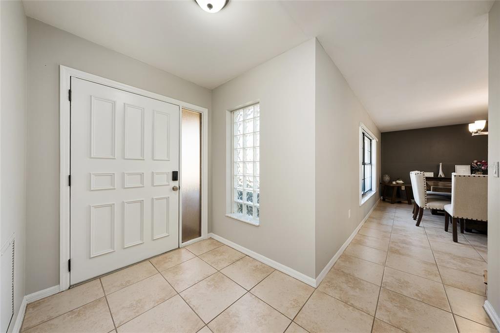 An entryway with tile flooring, a white front door, and a glass block window — 5201 NW 78TH COURT, OCALA, FL