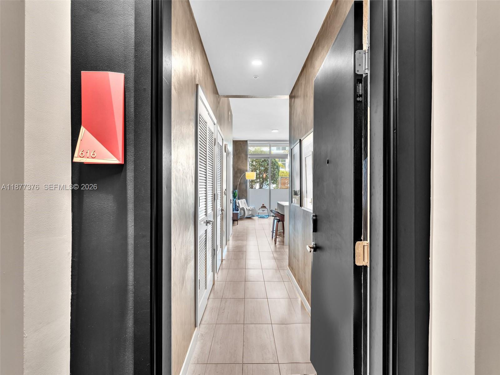 A view through an open doorway into a hallway leading to a bright living area — 3900 Biscayne Blvd # 616, Miami FL 33137, MIAMI, FL