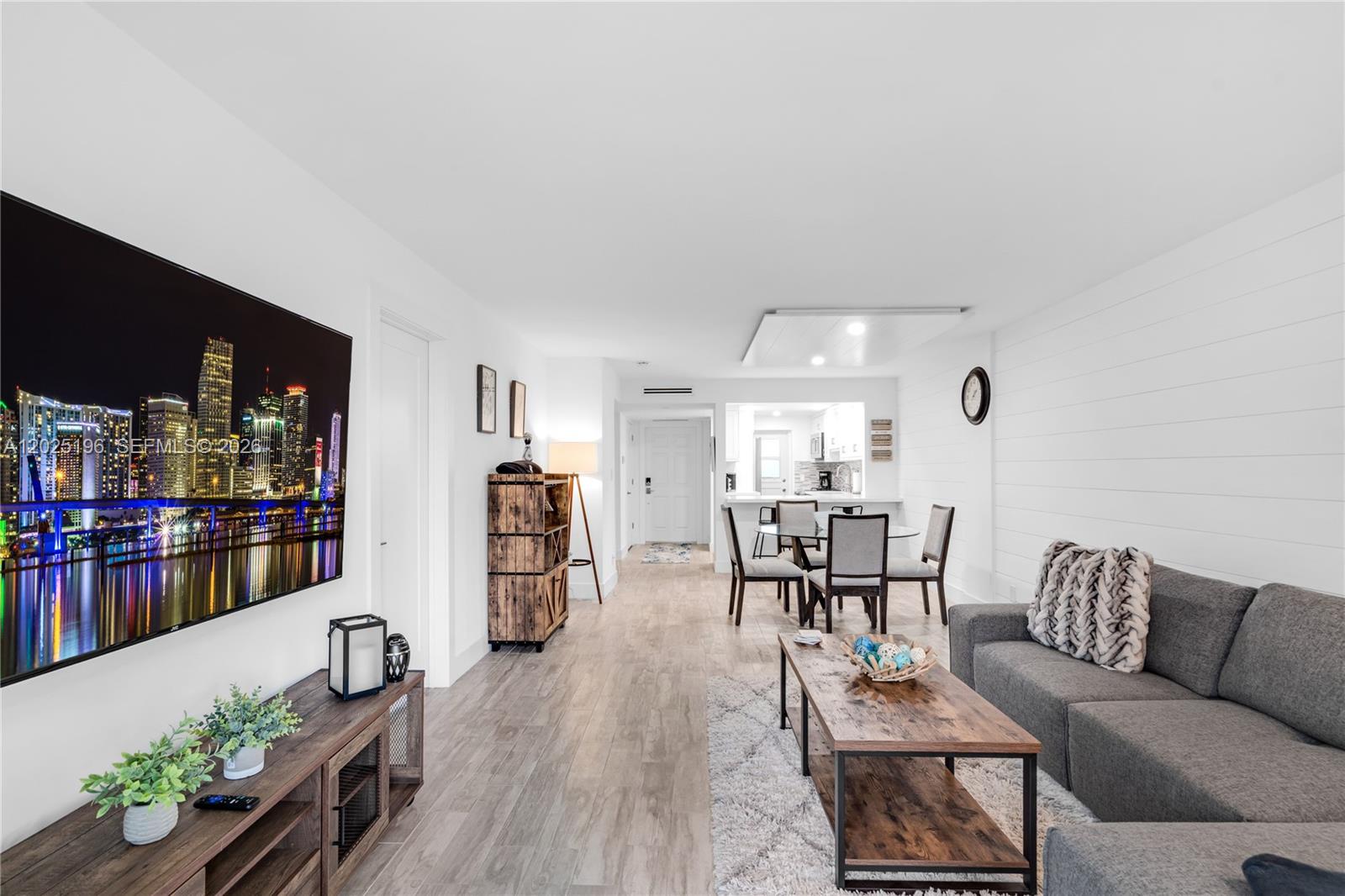 A living room and dining area feature wood-look flooring, white walls, and rustic furniture — 4502 N Federal Hwy # 167H, Lighthouse Point FL 33064, LIGHTHOUSE POINT, FL