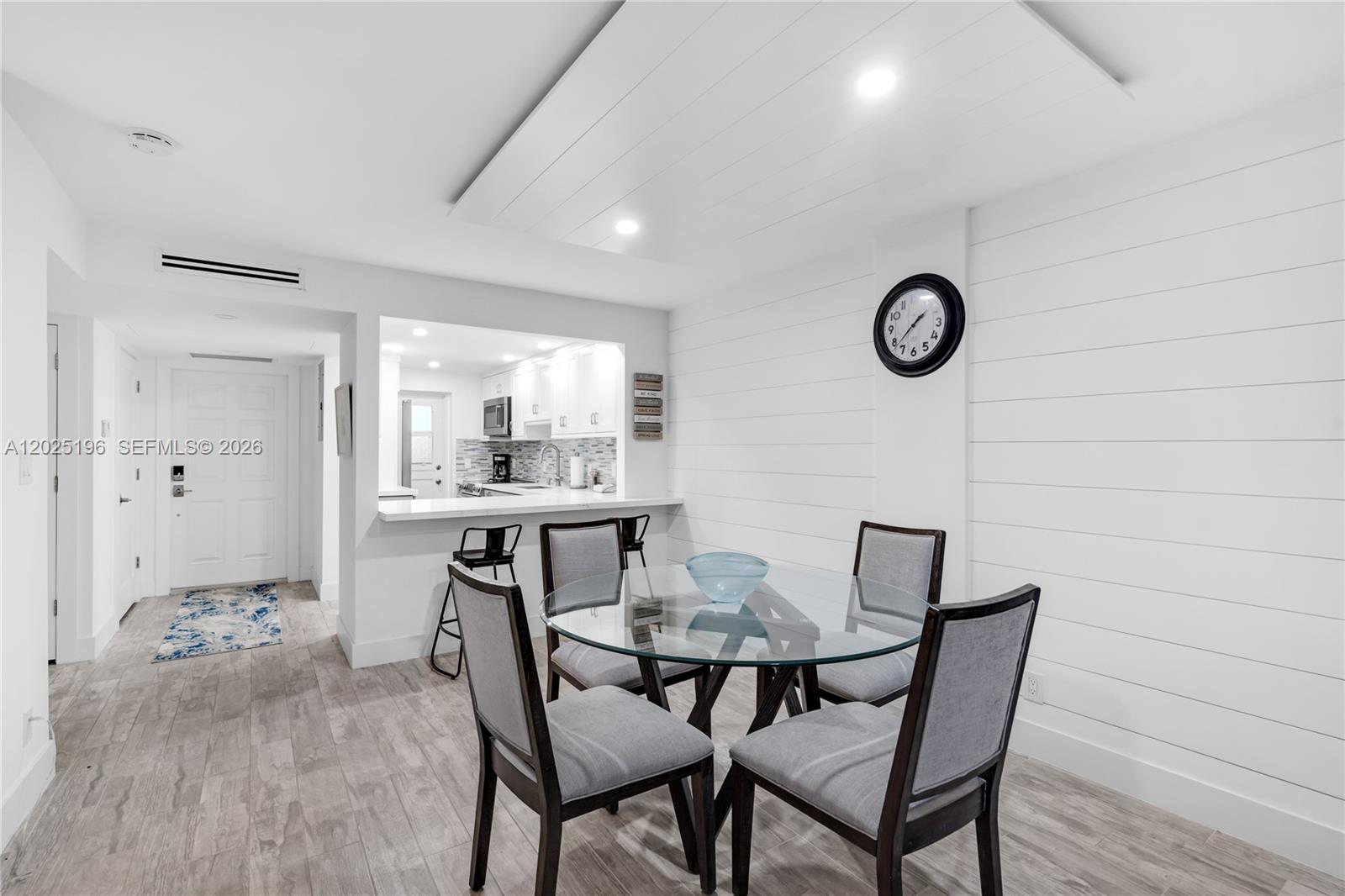 A dining area features a glass-topped table, four upholstered chairs, and white shiplap walls — 4502 N Federal Hwy # 167H, Lighthouse Point FL 33064, LIGHTHOUSE POINT, FL