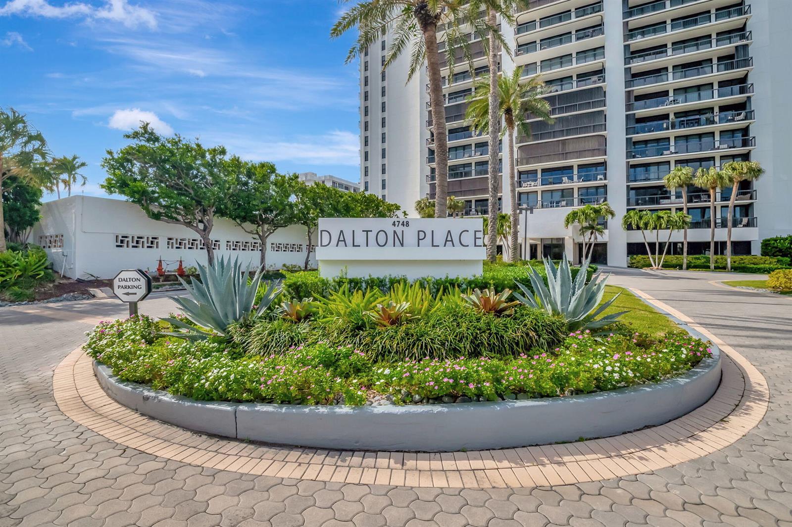 A circular driveway surrounds a landscaped garden with a sign for Dalton Place — 4748 S Ocean Boulevard # 203, Highland Beach FL 33487, HIGHLAND BEACH, FL