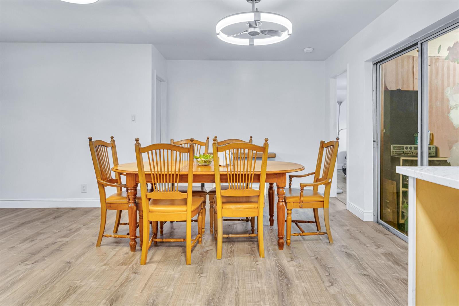 A dining room features a wooden table with six chairs under a circular ceiling fan — 4469 Brandon Drive, Delray Beach FL 33445, DELRAY BEACH, FL