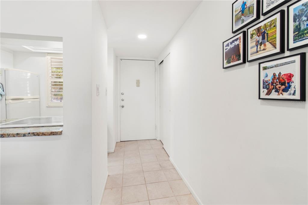 A tiled entryway leads to a white front door with a kitchen visible on the left — 4340 FALMOUTH DRIVE UNIT D-204, LONGBOAT KEY, FL