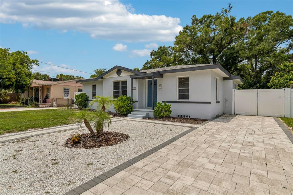 A single-story house with a white exterior, a paved driveway, and a gravel front yard — 4012 N BOULEVARD, TAMPA, FL