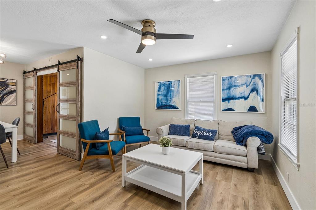 A living room features a beige sofa, two blue armchairs, a coffee table, and sliding doors — 4012 N BOULEVARD, TAMPA, FL