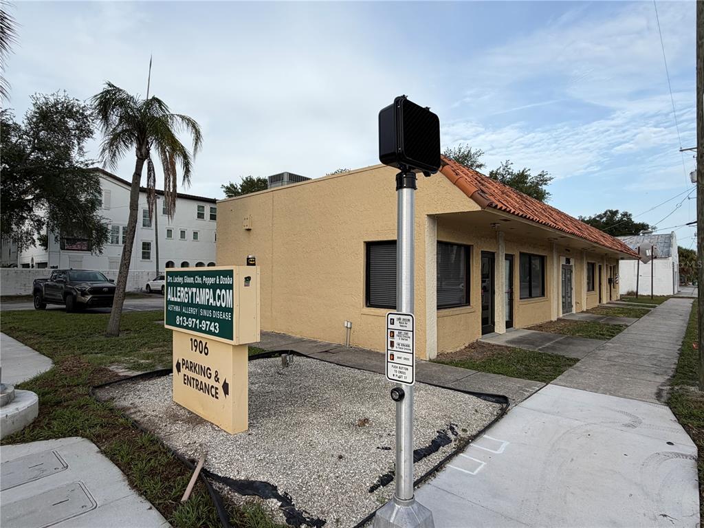A tan commercial building with a tile roof sits next to a sidewalk and sign — 1906 W PLATT STREET, TAMPA, FL