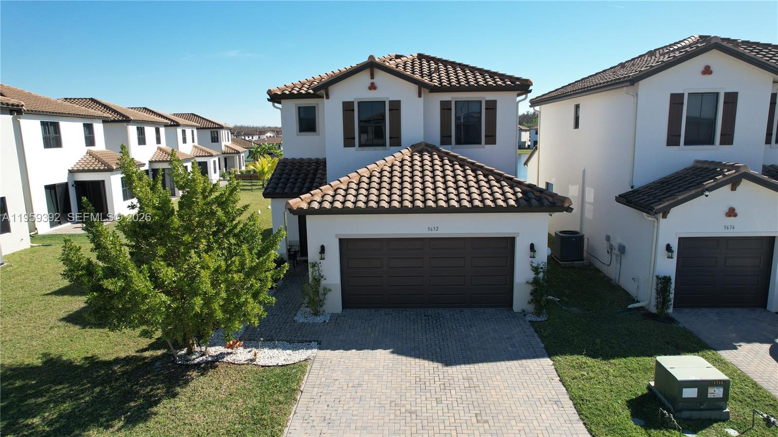 An aerial view shows a two-story house with a brown garage and tiled roof — 5632 Cerva LN, Ave Maria FL 34142, AVE MARIA, FL