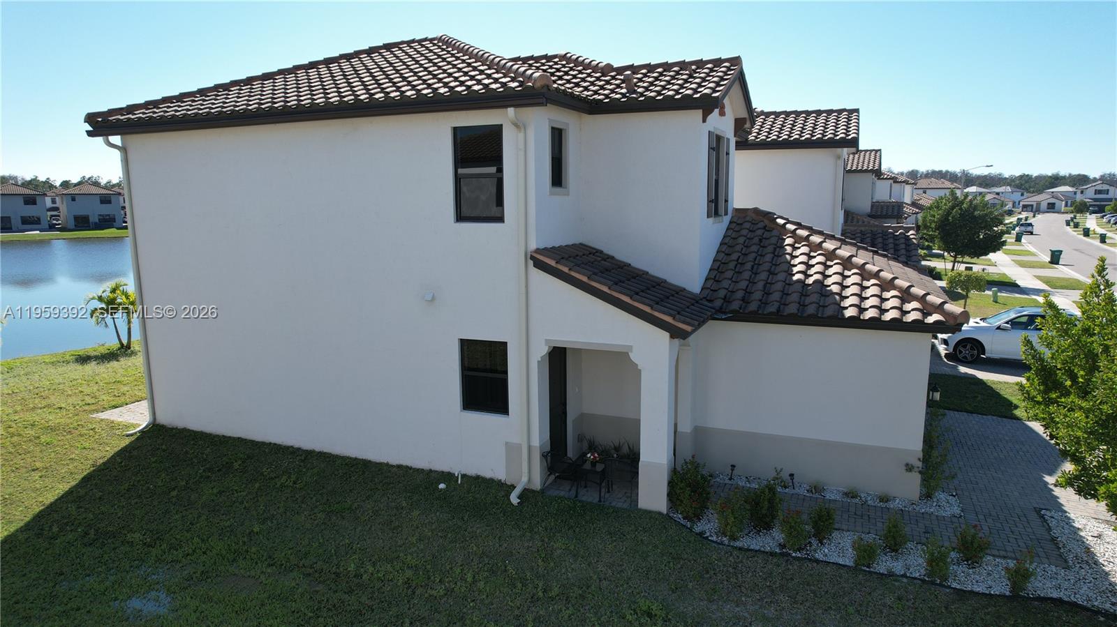 An exterior view of a two-story stucco house with a tiled roof and patio — 5632 Cerva LN, Ave Maria FL 34142, AVE MARIA, FL