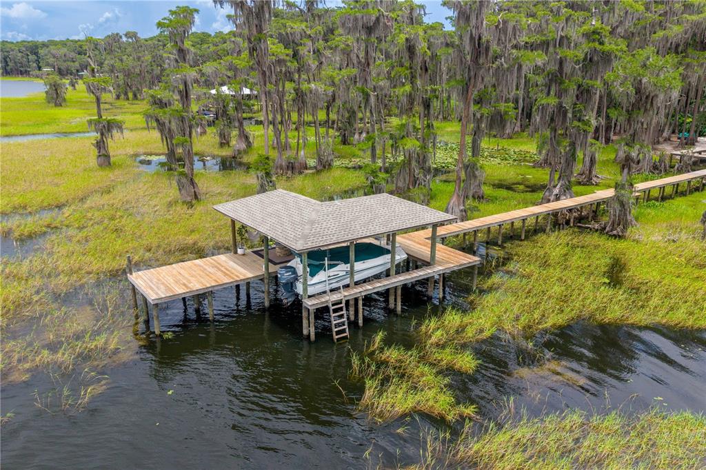 An aerial view of a boat dock with a covered slip and wooden walkway — 298 SE 5TH AVENUE, MELROSE, FL