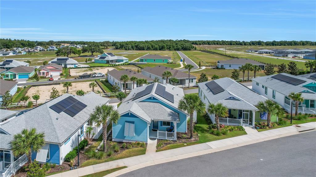 An aerial view shows several colorful suburban houses with solar panels on their roofs — 357 CONCH KEY LANE, LADY LAKE, FL