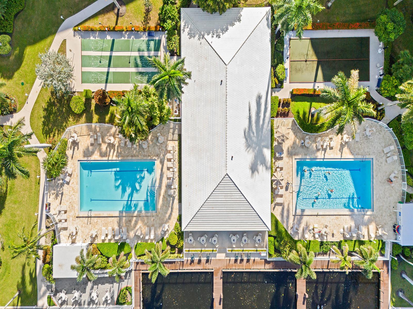An aerial view shows a community center with two swimming pools, shuffleboard courts, and docks — 3310 S Ocean Boulevard # d, Highland Beach FL 33487, HIGHLAND BEACH, FL