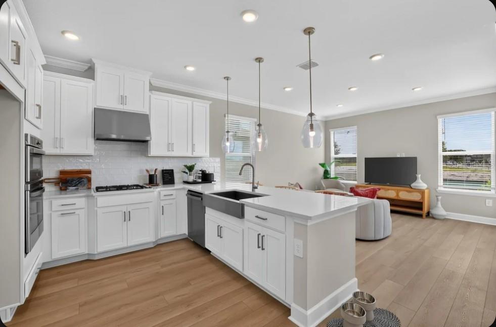 A modern kitchen with white cabinets, a large island, and stainless steel appliances — 662 LADYFISH TRAIL, ST CLOUD, FL