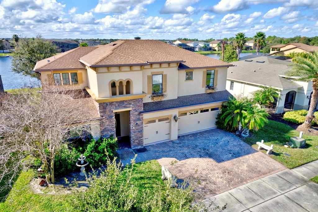 An aerial view of a two-story house with a stone facade and a paved driveway — 3110 BASS BOAT WAY, KISSIMMEE, FL