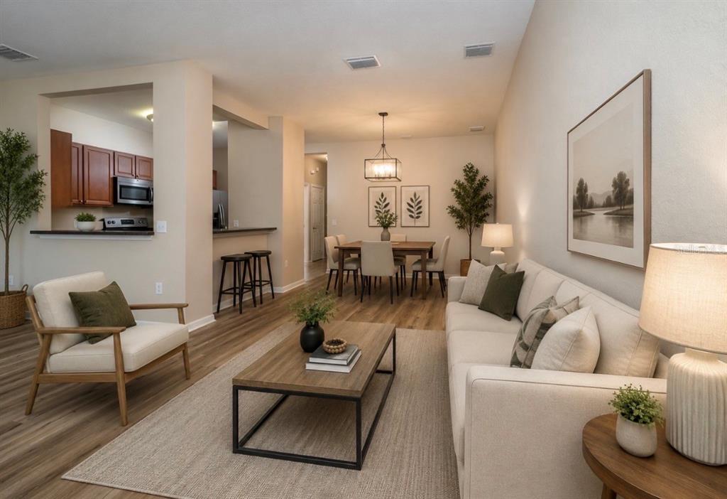 An open-concept living and dining area features light wood flooring, neutral furniture, and a kitchen — 7818 BALLY MONEY ROAD, TAMPA, FL