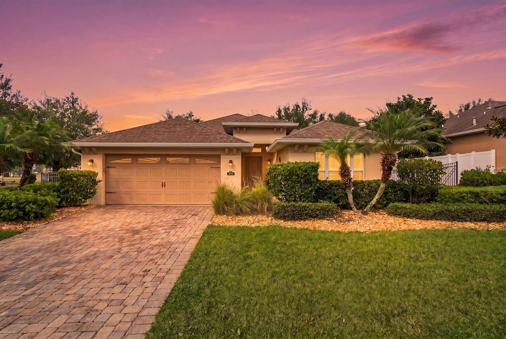 A single-story house with a paved driveway, a two-car garage, and a landscaped front yard — 476 SAUVIGNON WAY, GROVELAND, FL