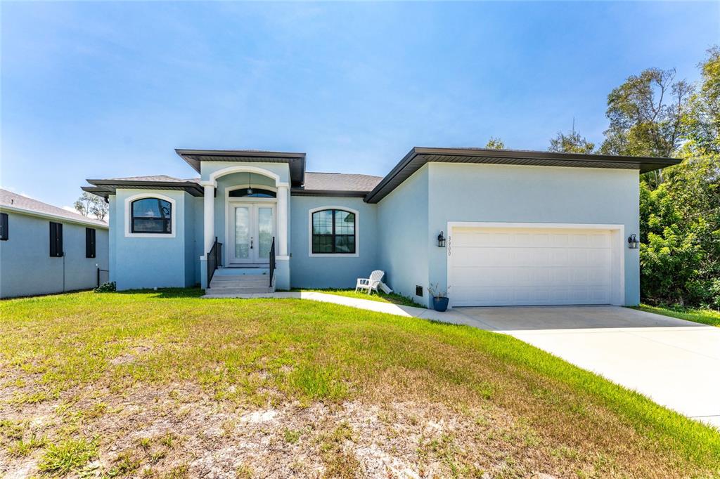 A light blue single-story house with a two-car garage and a front entryway — 3900 PALM DRIVE, PUNTA GORDA, FL