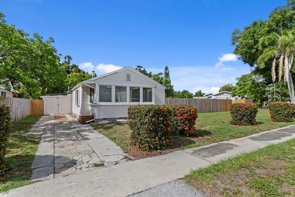 A light-colored, single-story house with a stone driveway and a fenced yard — 3152 13TH AVENUE N, ST PETERSBURG, FL