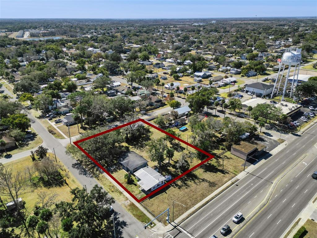 An aerial view shows a residential lot with a house outlined in red near a road — 1310 NEW YORK AVE, ST CLOUD, FL