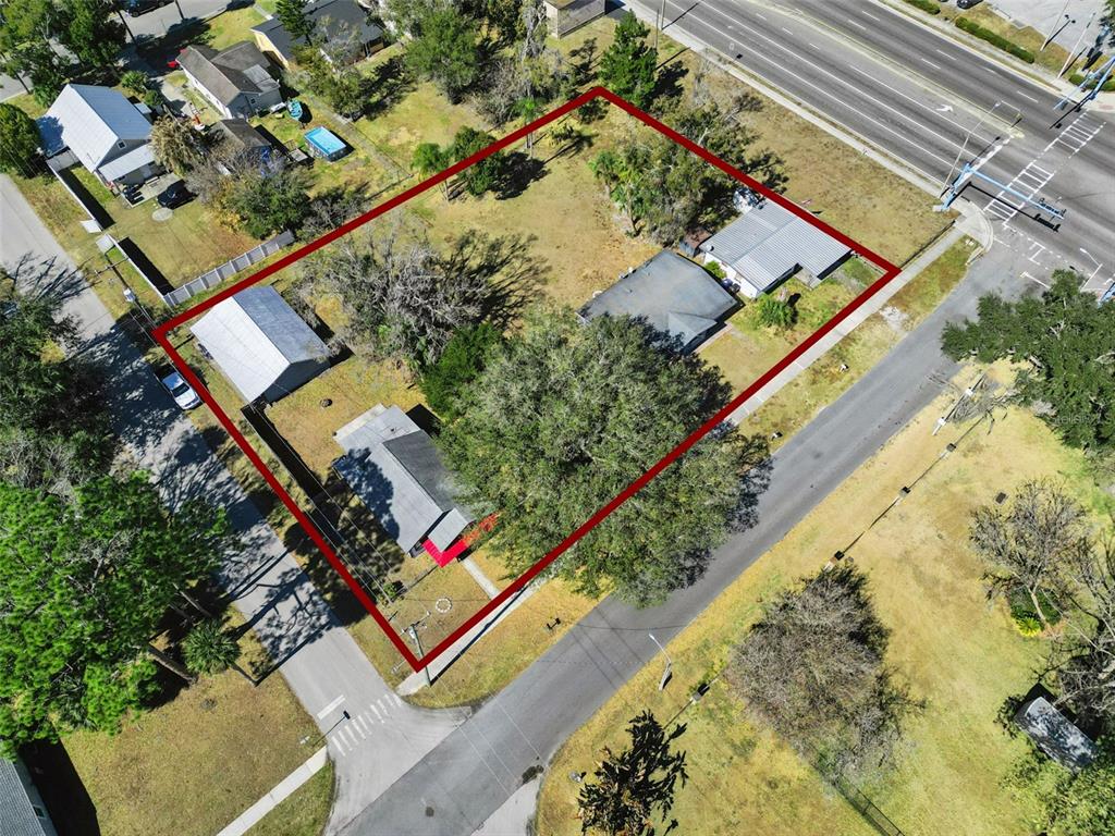 An aerial view shows a residential lot with two buildings and large trees — 1310 NEW YORK AVE, ST CLOUD, FL