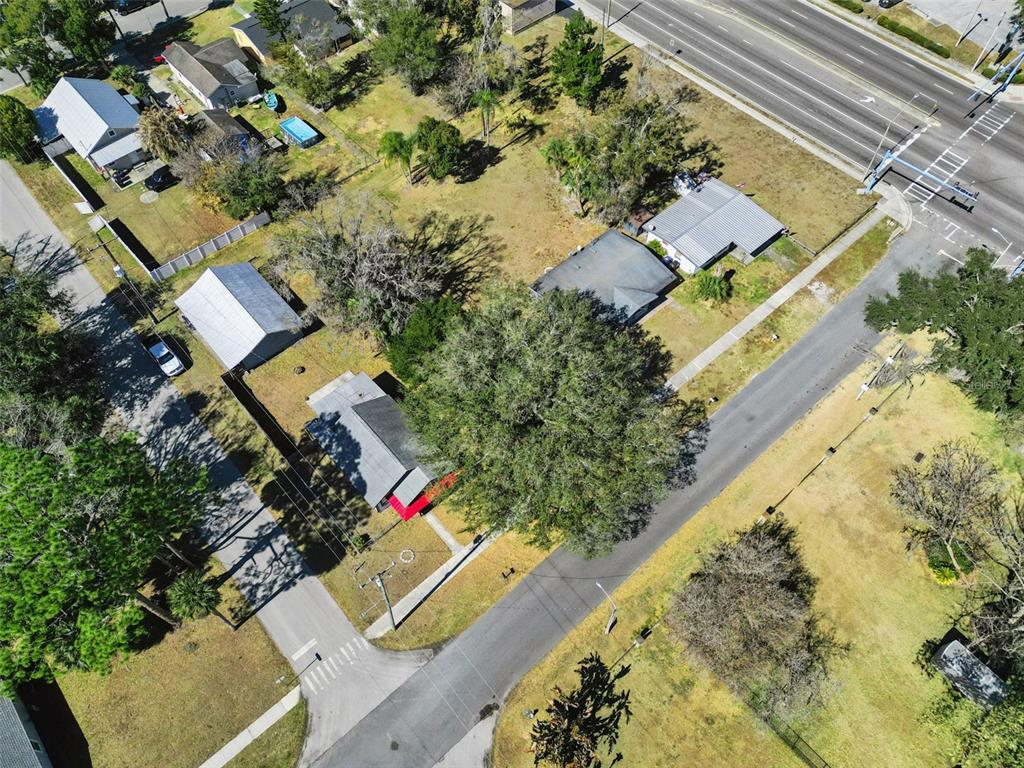 An aerial view shows several houses, a large tree, and a road intersection — 1310 NEW YORK AVE, ST CLOUD, FL