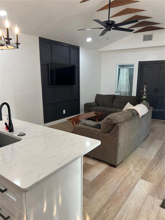 A living room with a dark accent wall, gray sofa, and a kitchen island — 311 E FLORIBRASKA AVENUE UNIT A, TAMPA, FL