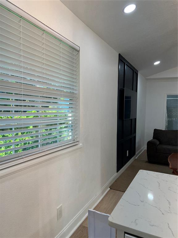 A room features a window with white blinds, a black accent wall, and a marble-topped island — 311 E FLORIBRASKA AVENUE UNIT A, TAMPA, FL