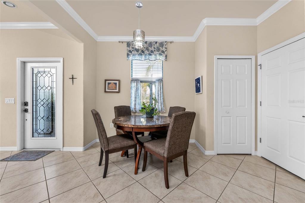 A dining area features a round table with four chairs, tile flooring, and a window — 20133 LAGENTE CIRCLE, VENICE, FL