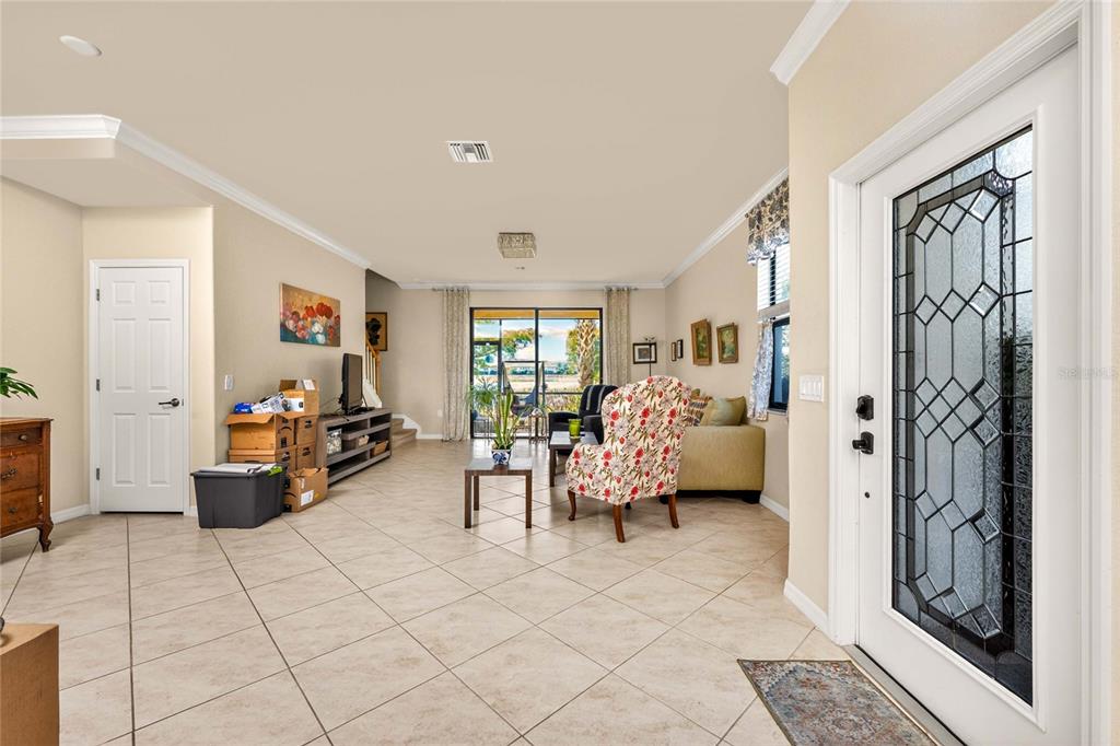 A view from an entryway into a living room with tile floors and sliding doors — 20133 LAGENTE CIRCLE, VENICE, FL