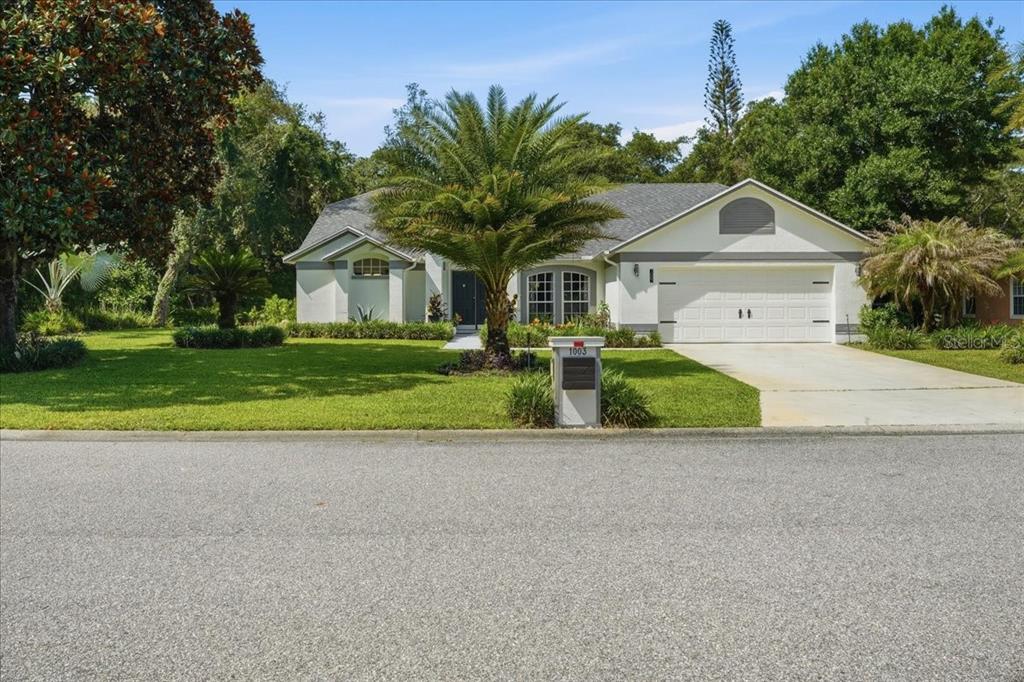 A single-story house with a white exterior, a two-car garage, and a palm tree — 1003 OLD CUTLER ROAD, LAKE WALES, FL