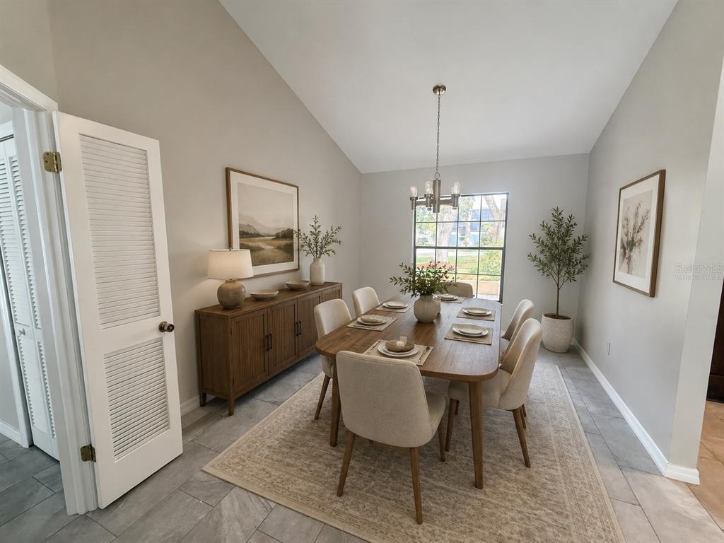 A dining room features a wooden table, six chairs, a sideboard, and a vaulted ceiling — 18306 FELSPAR WAY, TAMPA, FL