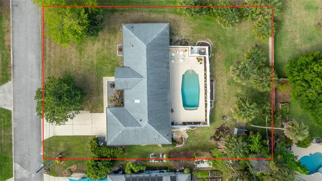 An aerial view shows a house with a gray roof, a pool, and a large yard — 2225 JUANITA DRIVE, NEW SMYRNA BEACH, FL