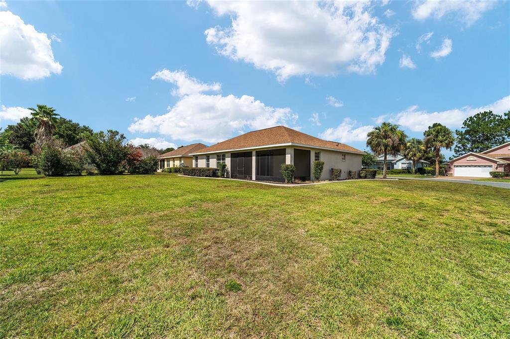 An entryway with tile flooring opens into a living area featuring wood-look floors and sliding doors — 8907 SW 84TH CIRCLE, OCALA, FL