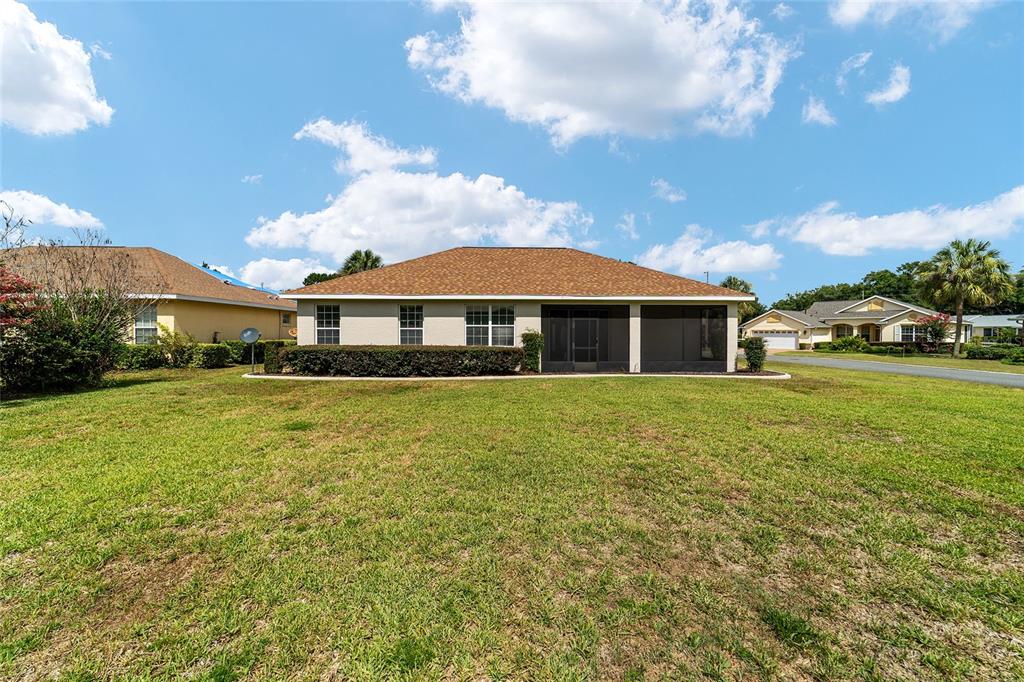 A living room with a beige sofa, coffee table, and an open kitchen in the background — 8907 SW 84TH CIRCLE, OCALA, FL
