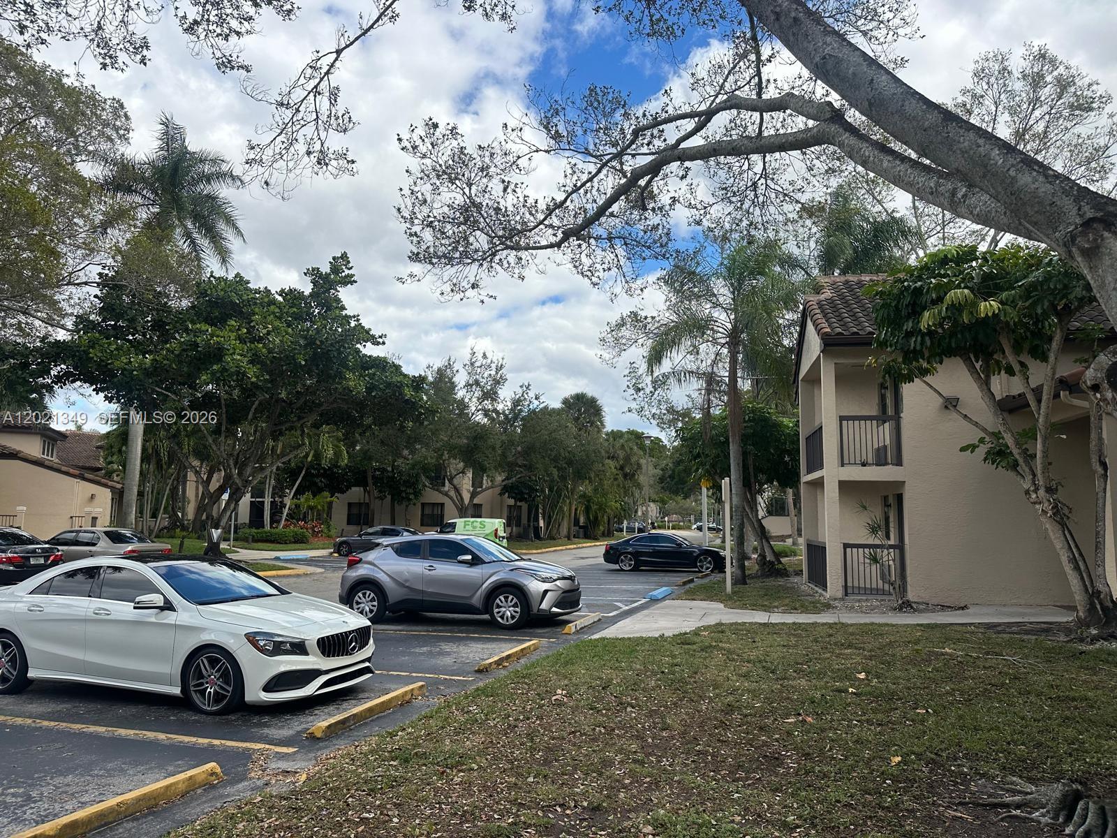 A parking lot sits in front of multi-story apartment buildings surrounded by trees — 4481 W Mcnab Rd # 37, Pompano Beach FL 33069, POMPANO BEACH, FL