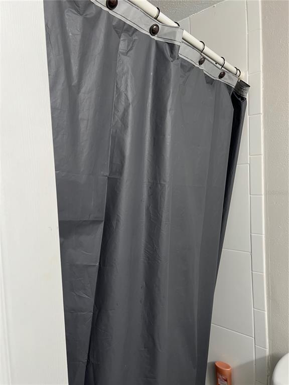 A gray shower curtain hangs from a rod in a tiled bathroom — 800 N FISKE BOULEVARD UNIT 506, COCOA, FL
