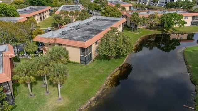 An aerial view shows a multi-story apartment building with a flat roof next to a pond — 182 Lakeview Dr # 204, Weston FL 33326, WESTON, FL