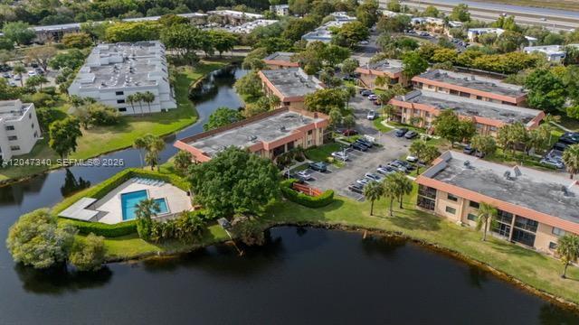 An aerial view shows apartment buildings surrounding a lake with a swimming pool and parking — 182 Lakeview Dr # 204, Weston FL 33326, WESTON, FL