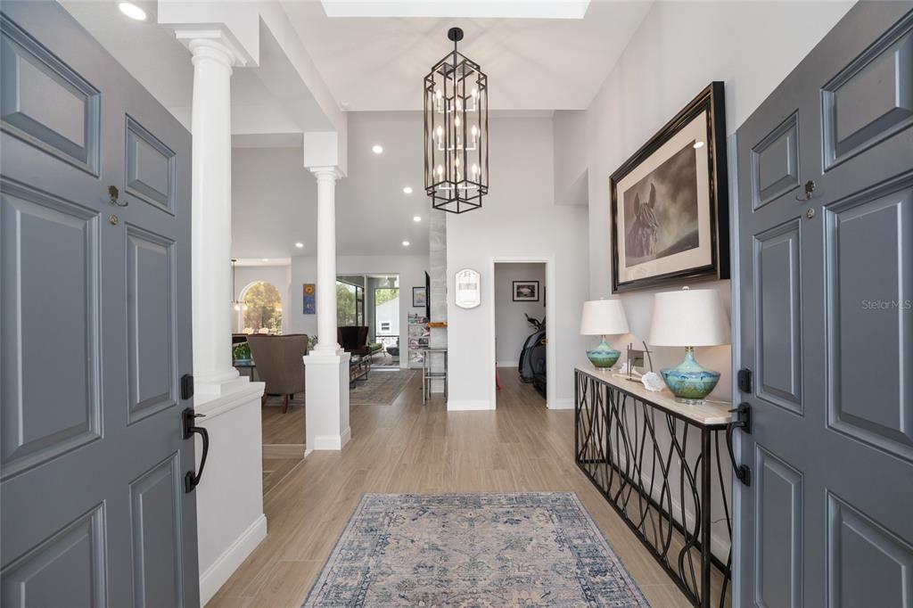 A foyer features a metal lantern pendant light, a console table, and light wood flooring — 10516 SW 27TH AVENUE, OCALA, FL