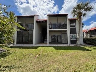 A two-story apartment building features screened balconies, dark window frames, and a central stairwell — 3233 BENEVA ROAD UNIT 104, SARASOTA, FL