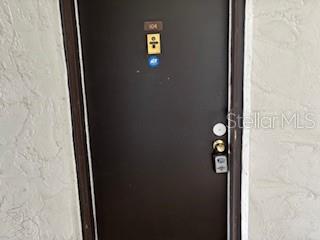 A dark brown apartment door with a gold peephole and a digital keypad lock — 3233 BENEVA ROAD UNIT 104, SARASOTA, FL