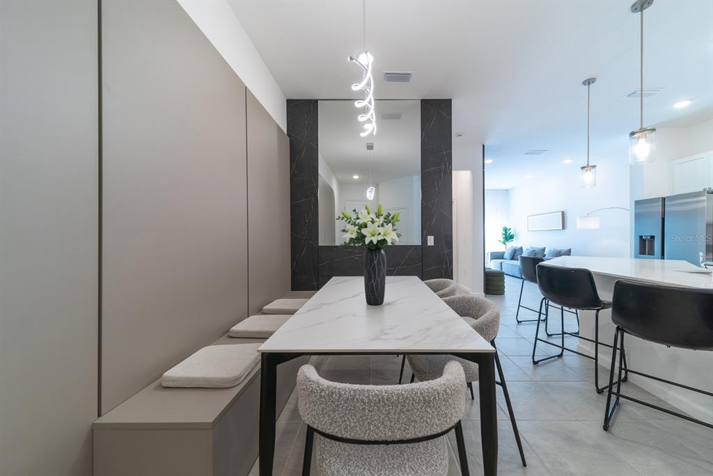 A dining area features a marble-topped table, built-in bench seating, and a dark stone accent wall — 10364 EBB TIDE LANE, ORLANDO, FL